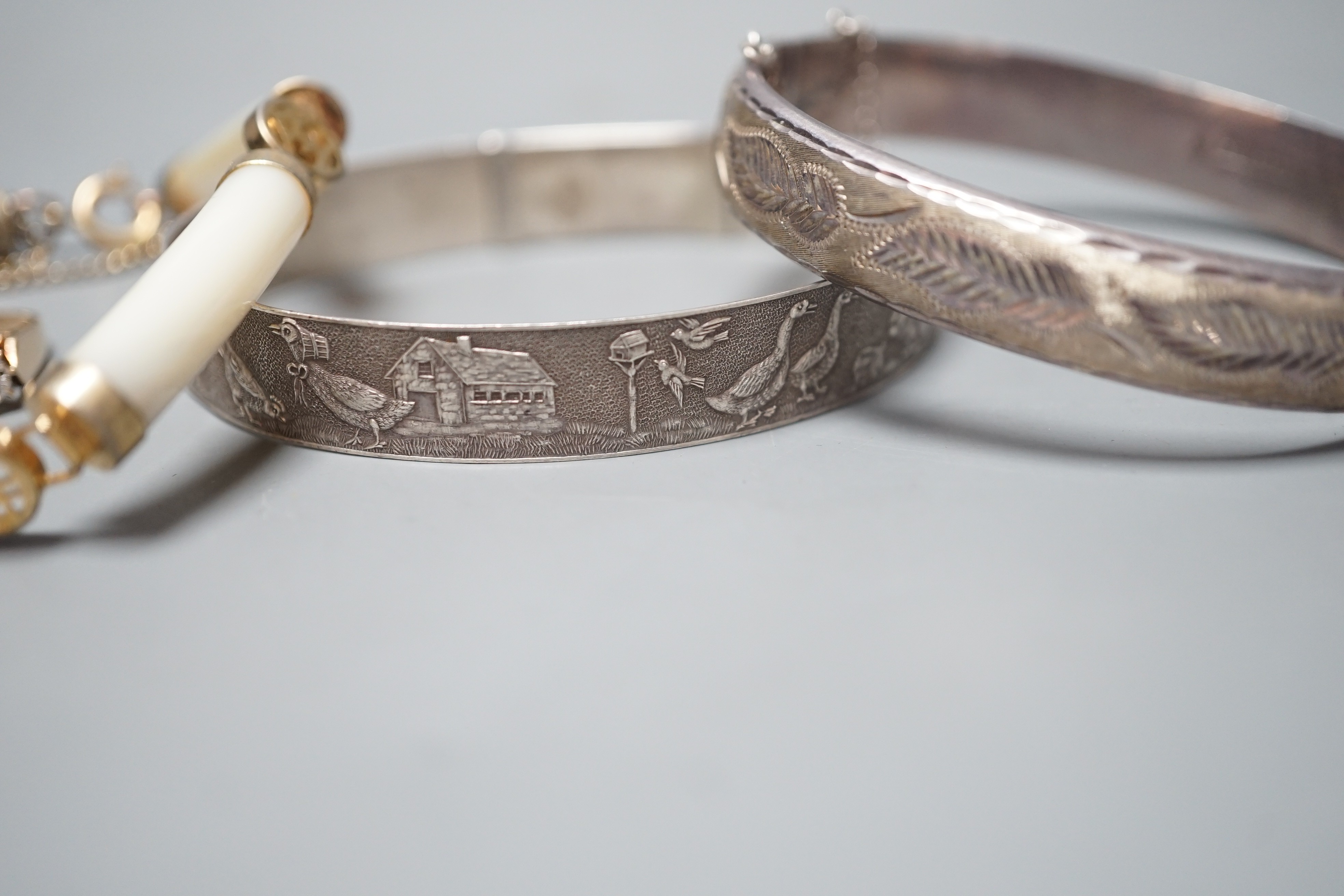 A modern 9ct gold and illusion set three stone diamond ring, size N/O, a Chinese gilt metal and mother of pearl bracelet and two white metal bangles, one hallmarked silver.